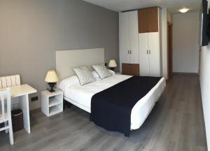 索拉雷斯Hosteria La Moraleja的卧室配有一张白色大床和一张书桌