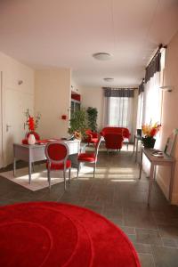 莫迪苏尚特多美恩德山特梅勒酒店的客厅配有红色椅子和红色地毯