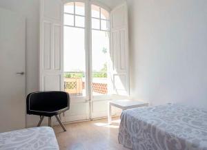 圣库加特德尔瓦勒斯Tu Casa en Barcelona的卧室配有床、椅子和窗户。