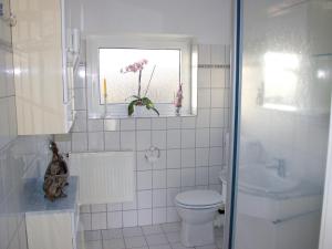 希尔克道夫Ostseehaus Oe的白色的浴室设有卫生间和窗户。
