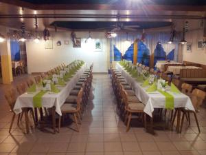 多瑙河畔韦尔特Gasthof Pflamminger的宴会厅的一排桌子,上面摆放着绿色餐巾