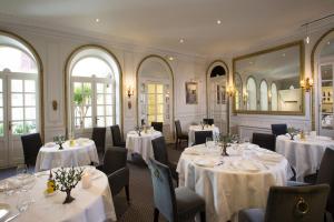 阿维尼翁欧洲酒店的餐厅配有白色的桌椅和镜子