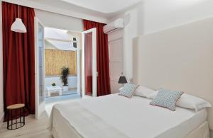 卡普里Fuorlovado 40的卧室配有白色的床和红色窗帘