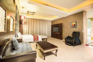 斗六市观月商务休闲旅馆的酒店客房,配有床和沙发