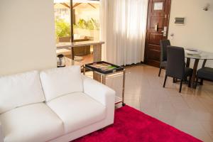 罗安达罗安达大陆酒店的客厅配有白色沙发和红色地毯。