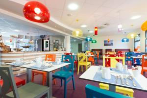 拉罗谢尔罗歇尔中心齐亚迪酒店 - 莱斯米尼蒙的餐厅配有色彩鲜艳的桌椅