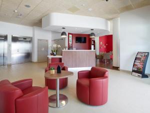 阿莱斯Campanile Ales Centre - Cévennes的大堂设有红色椅子、桌子和柜台