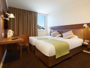 阿莱斯Campanile Ales Centre - Cévennes的酒店客房配有两张床和一张书桌