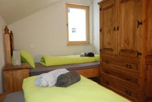 施库尔Feriendorf Uorsin的一间卧室设有两张床、一个梳妆台和窗户。