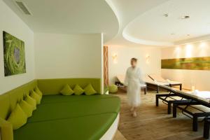 加舒恩桑布里克酒店的一位女士在带绿色沙发的客厅里散步