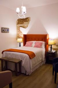 危地马拉梅拉奇精品酒店的一间卧室配有一张大床和两盏灯。