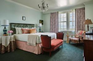 新奥尔良庞恰特雷恩湖圣查尔斯大街酒店的一间卧室配有一张床、一把椅子和一个吊灯。