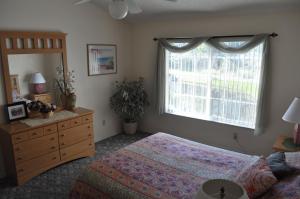 基西米拉古纳湾别墅公寓的一间卧室配有一张床、一个梳妆台和一扇窗户。