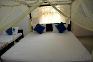 Habawewa位帕图野生观景酒店的一间卧室配有白色床和蓝色枕头