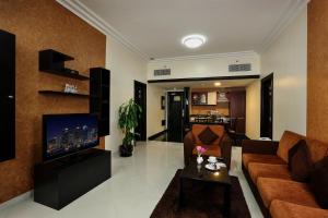 沙迦皇家豪华套房酒店的带沙发和电视的客厅