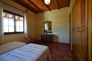 埃尔帕索Casas Rurales Tola的一间卧室配有两张床、一个梳妆台和镜子