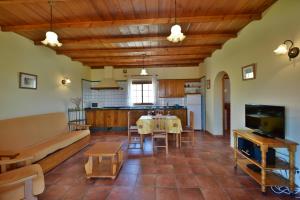 埃尔帕索Casas Rurales Tola的一间带桌子的客厅和一间厨房