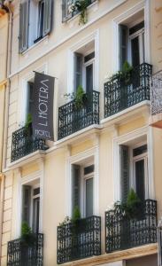 戛纳Hotel l'Hotera的酒店外墙设有阳台和植物