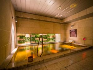 大阪Super Hotel Premier Osaka Honmachi Ekimae Natural Hot Springs的客房内的浴缸及淋浴