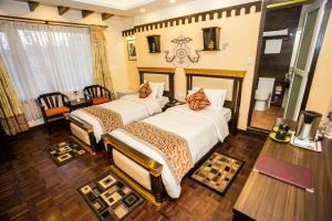 加德满都遇见尼泊尔&spa酒店的酒店客房设有两张床和一张桌子。