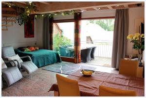 埃朗根艾艾姆博格伯格公寓的一间卧室配有一张床铺和一张桌子,并设有一个阳台