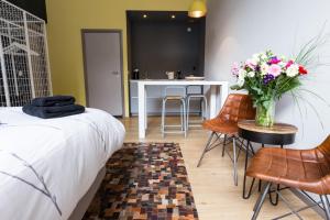 阿姆斯特丹阿姆斯特丹之家工艺品酒店的一间卧室,配有一张床和一张花瓶上的桌子
