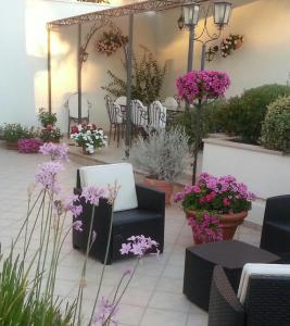 梅萨涅加蒂诺Il号德勒塞特住宿加早餐旅馆的庭院里种有紫色花卉,配有桌椅