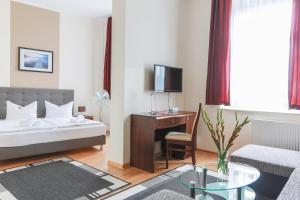 奥得河畔法兰克福法兰克福/奥得河车站城市公寓酒店的酒店客房设有一张床和一张带电视的书桌。