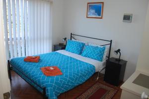 莱克斯恩特伦斯卢考特假日公寓的一间卧室配有蓝色的床和2条毛巾