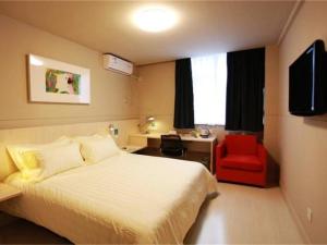焦作锦江之星焦作建设路酒店的酒店客房,配有一张床和一张红色椅子