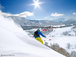 小谷村绿色广场白马酒店的一个人在雪覆盖的斜坡上滑雪