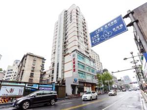 萧山锦江之星萧山杭州乐园酒店的街道标志,汽车沿着城市街道行驶