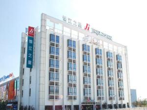 上海锦江之星上海虹桥枢纽国家会展中心酒店的一座白色的大建筑,上面有标志