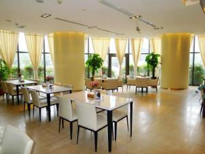 祭城镇锦江之星郑州国际会展中心酒店的用餐室设有桌椅和窗户。