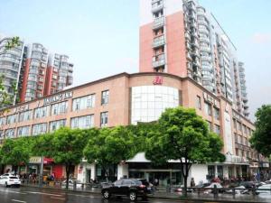 苏州锦江之星吴江中山北路步行街酒店的城市街道上一座大型砖砌建筑,有汽车