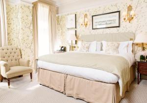 伦敦伦敦斯塔福德酒店的一间卧室配有一张大床和一把椅子