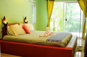 帕克蒙帕克蒙海滩度假旅馆的绿色客房内的一张床铺,设有大窗户