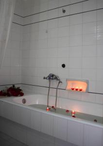 特尔斐克鲁罗斯酒店的浴缸配有两把蜡烛和水龙头