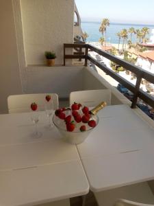 拉海瑞德拉HH Apartamento La Herradura Playa的桌子,上面放着一碗草莓和酒杯
