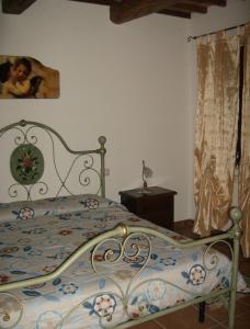 阿夸彭登泰La Quiete的一间卧室配有一张带花卉床罩的床