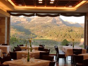 BotHotel & Spa Can Josep的餐厅设有桌椅和大窗户。