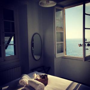 卡莫利Al Piccolo Scoglio - Room & Breakfast的一间卧室配有一张床、镜子和窗户