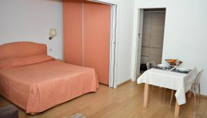 米兰贝利萨里奥费拉米兰诺公寓的一间小卧室,配有一张床和一张桌子