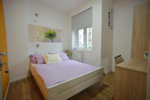 贝尔格莱德斯特拉诺特旅馆的一间卧室配有一张带粉色床单的床和一扇窗户。