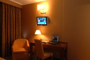 卡斯特罗齐耶罗利欧拉酒店的酒店客房配有带笔记本电脑的书桌和电视。