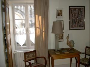 BeurlayMaison Lépie的客房设有窗户和带台灯的桌子
