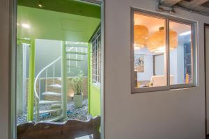 暖武里府ST88汽车旅馆的一间设有绿色墙壁的客房和一个带镜子的楼梯