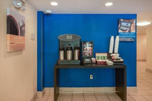 米尔福德米尔福德6号汽车旅馆的蓝墙,带桌子和瓶装葡萄酒