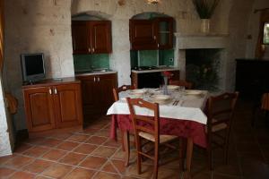 卡斯特拉纳格罗泰Masseria La Luna Nel Pozzo的厨房配有桌椅和电视。