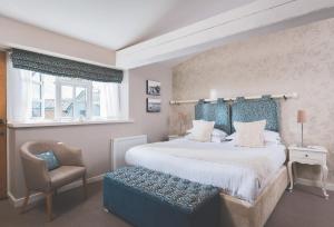 埃克塞特全球酒店的一间卧室配有一张大床和一把椅子
